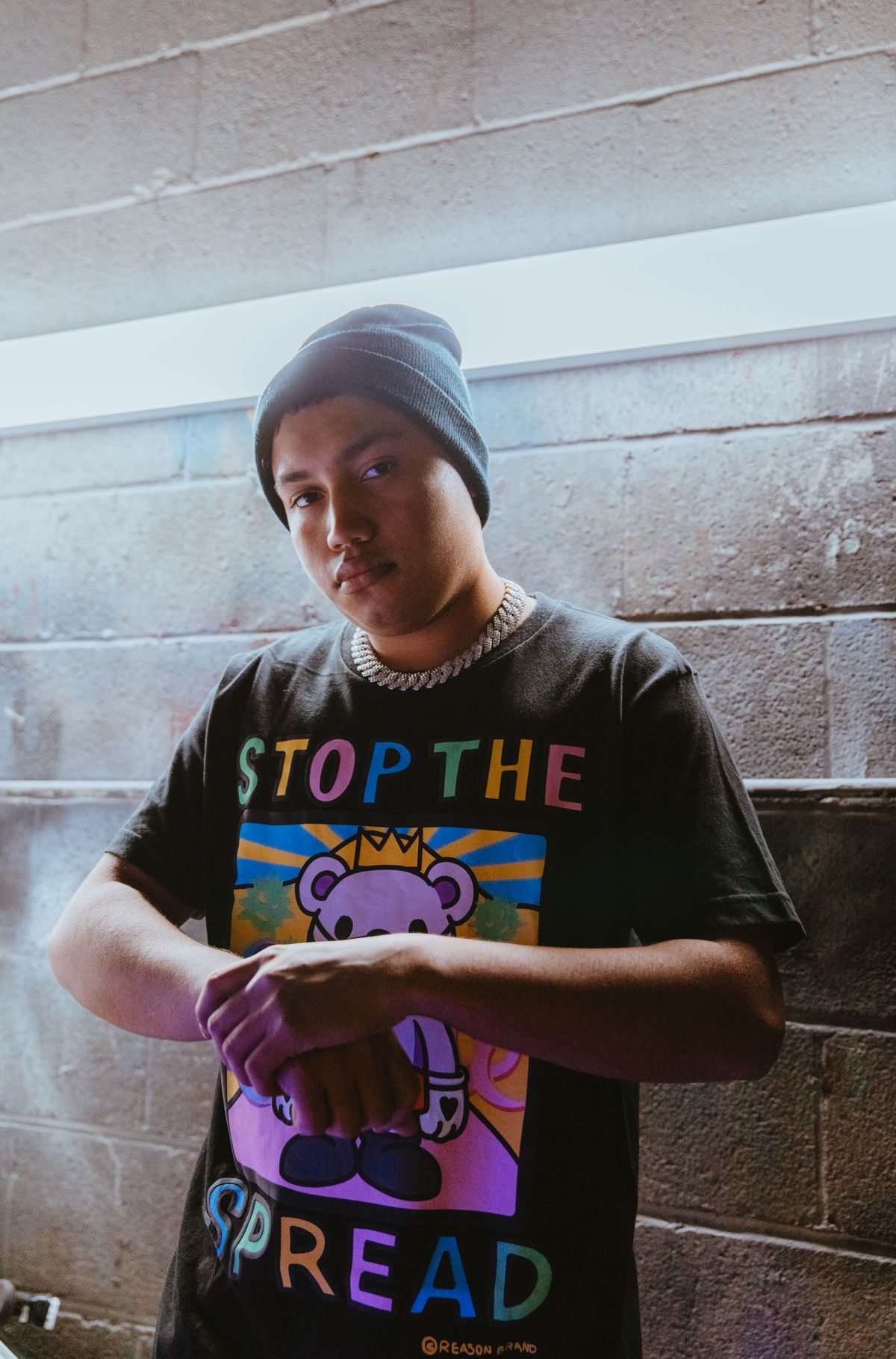 Young man in a beanie wearing a bold black graphic streetwear T-shirt
