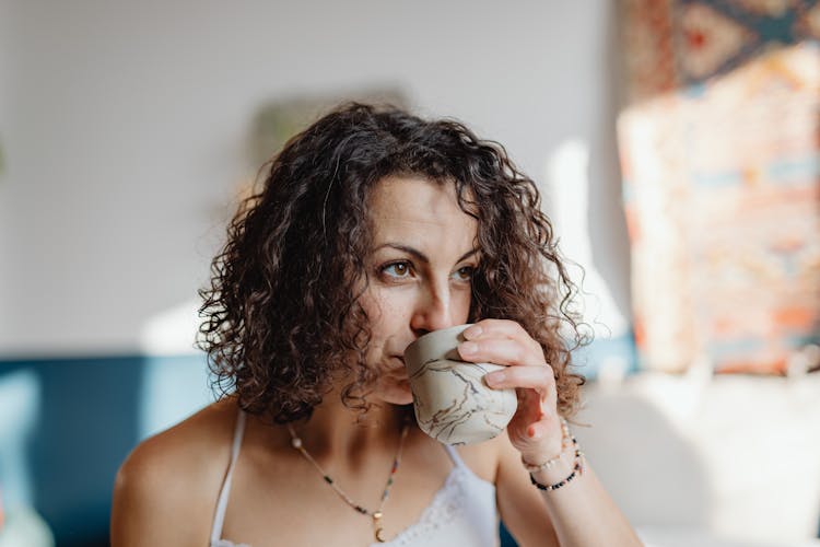 A Woman In White Spaghetti Strap Top Drinking A Hot Coffee