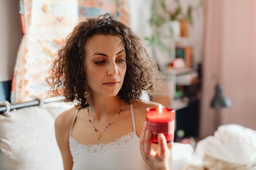Woman in White Tank Top Holding Lighted Candle