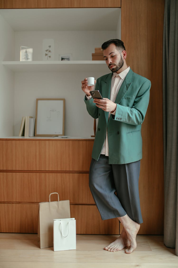Elegant Man Using Smart Phone And Drinking Coffee 