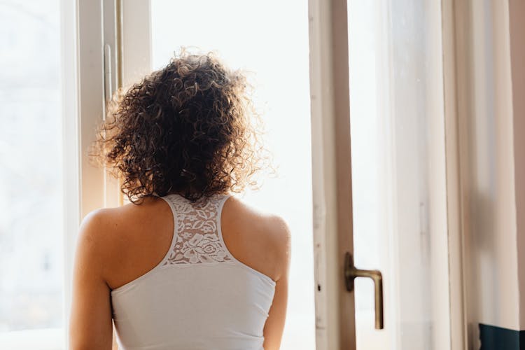 Woman Standing In Front Of An Open Window 