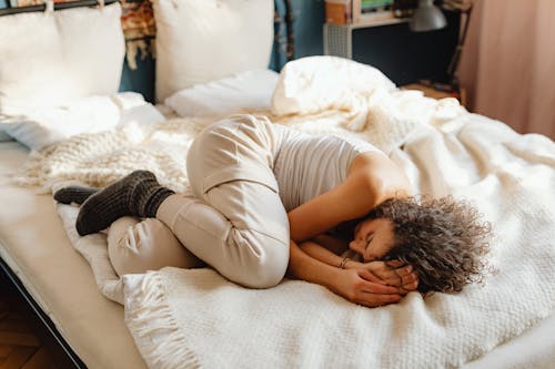 Free Young Woman Sleeping in Fetal Position Stock Photo