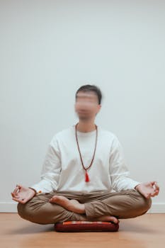 Adult man practicing meditation in a serene indoor setting, focused on mindfulness.