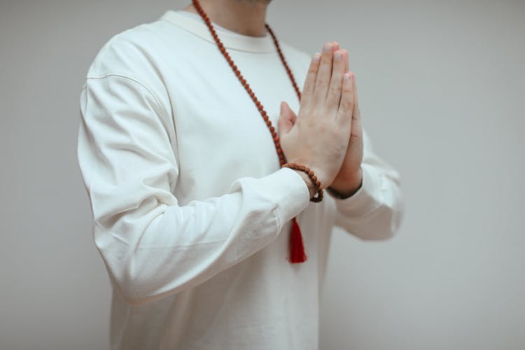 Man In White Long Sleeve Shirt In Praying Hands
