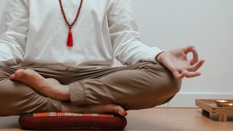 Close-up of a person meditating in a serene indoor setting, focusing on mindfulness.