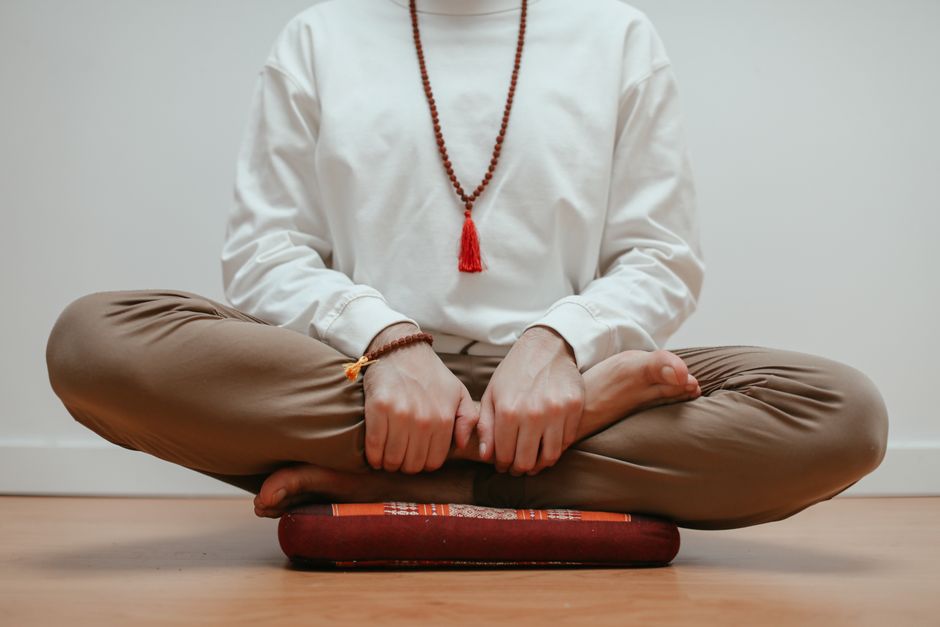 Person in a meditative posture indoors — setting intention before iboga ceremony provides a direction; the medicine will reveal what needs to be seen regardless of what you intend