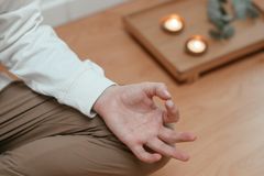 A serene close-up of a person meditating indoors with candles and a peaceful ambiance.