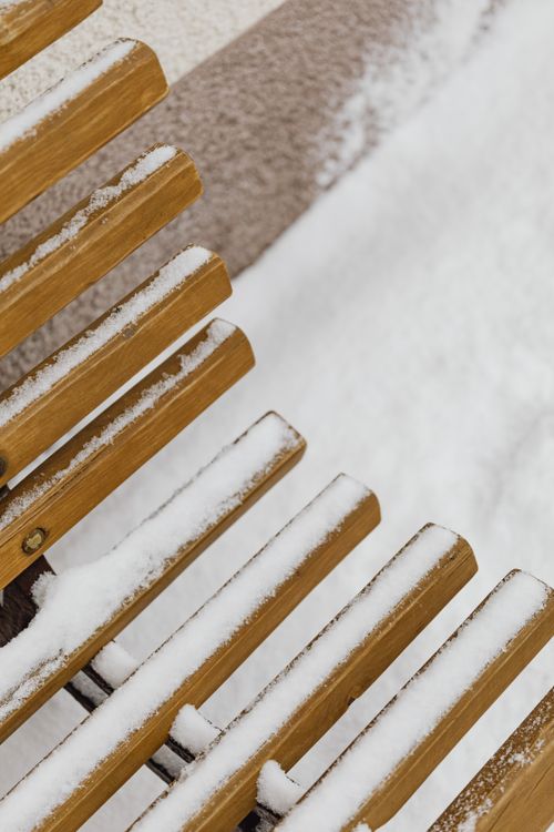 Free Close-up of a snow-covered wooden bench outdoors in winter weather. Stock Photo