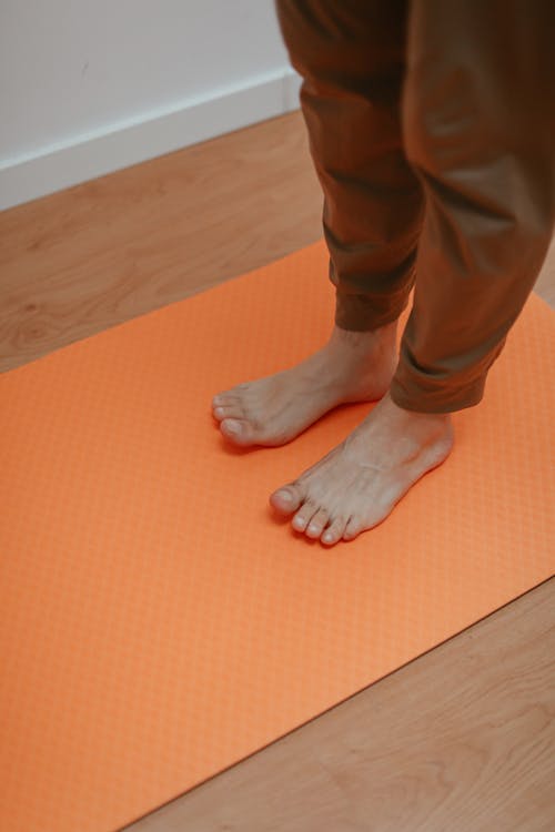 Free Person in Brown Pants Standing on Orange Mat Stock Photo