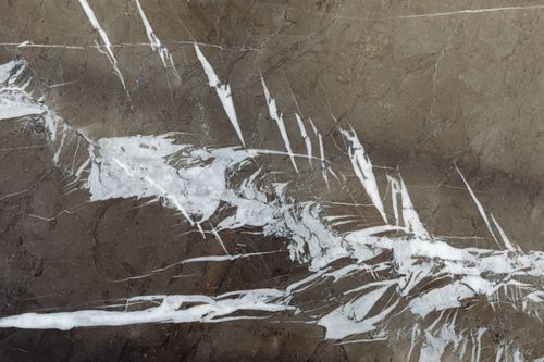 Free Close-up of brown marble surface with intricate white veins creating an abstract pattern. Stock Photo