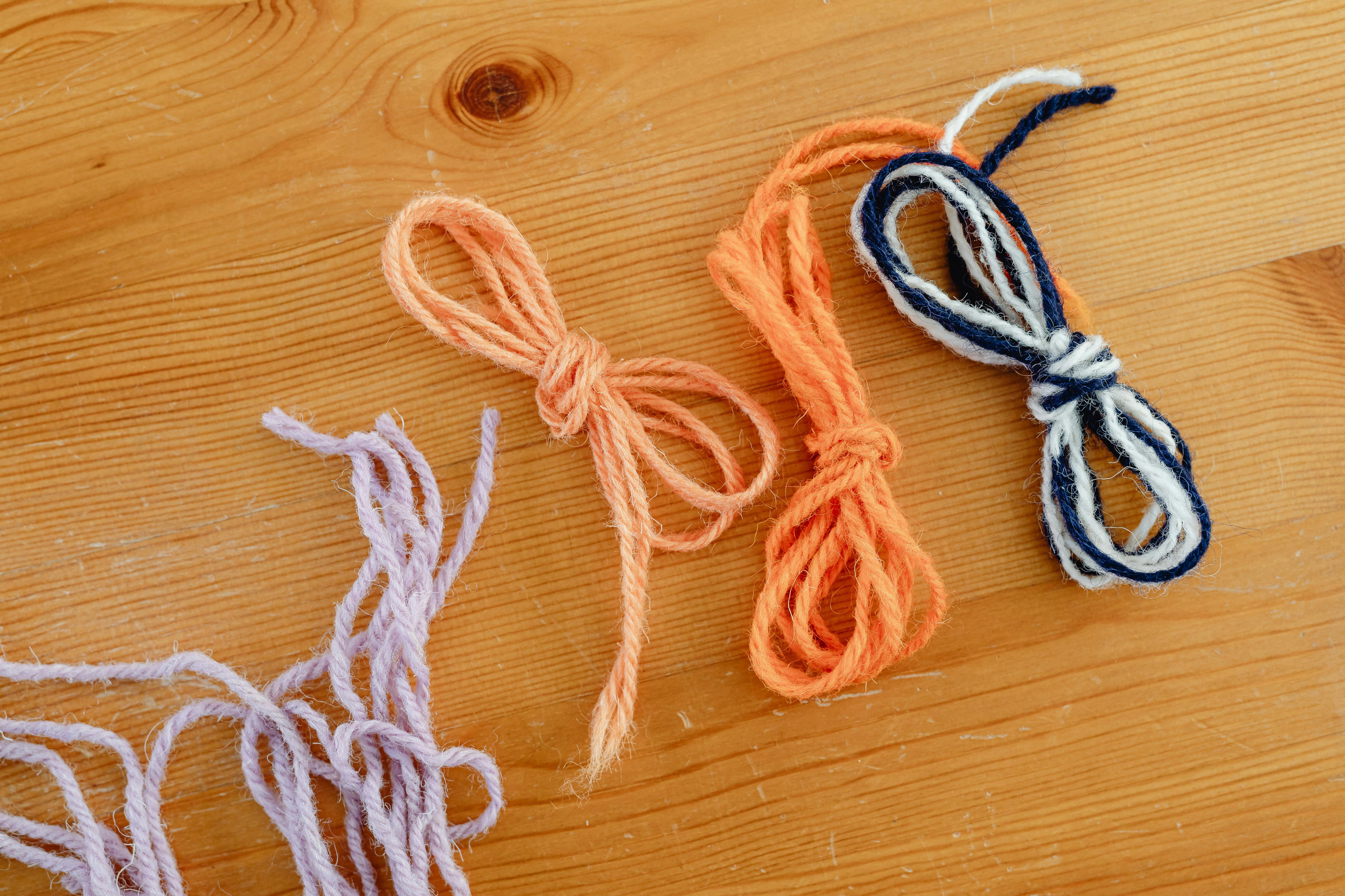 Close-up of colorful yarn bundles neatly arranged on a wooden table surface.