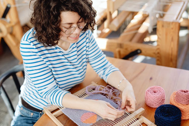 Woman Weaving With Wool Threads On Machine