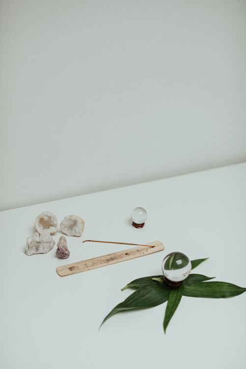 Free Minimalist still life featuring crystals, leaves, and a glass sphere on a white background. Stock Photo