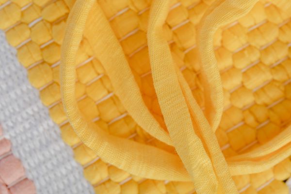 Yellow woven textile with twisted fabric strands — photo by Kaboompics on Pexels