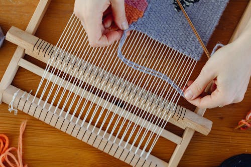 Close-up of the Hands of a Weaver Working with a Loom