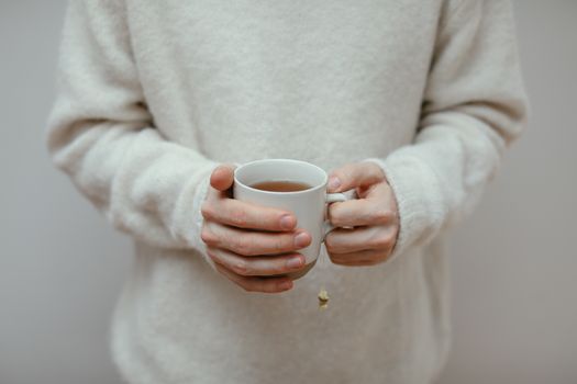 hands holding cup of tea