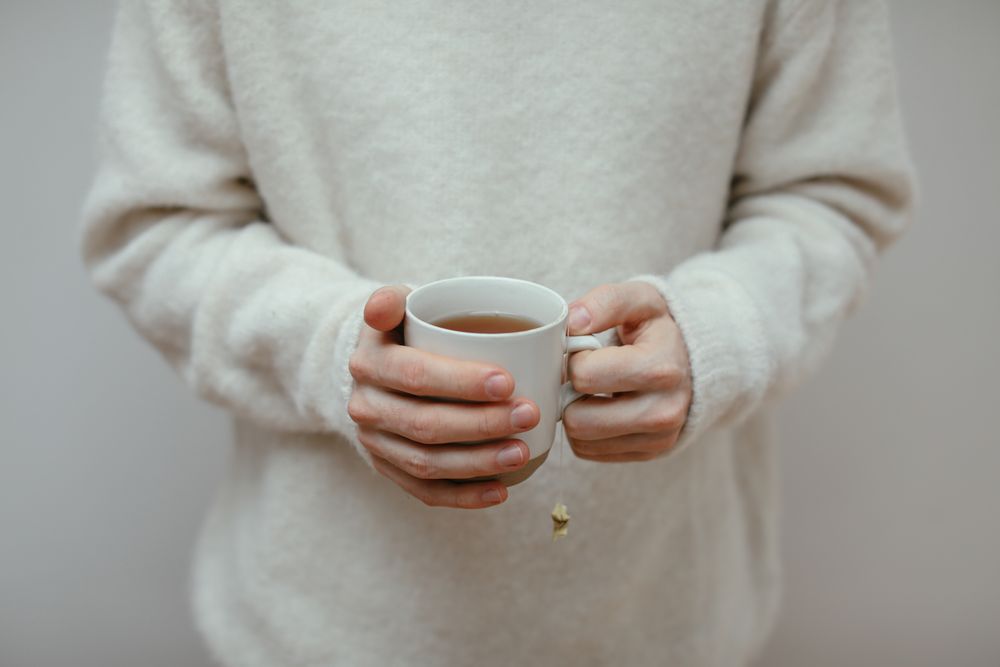 Mains tenant une tasse chaude pendant un moment de réflexion calme