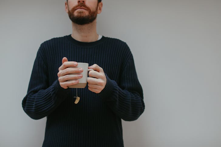 Bearded Man Wearing Sweater Holding a Cup