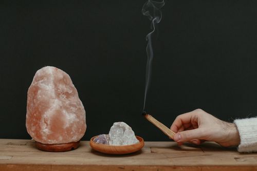 Free A serene setup with Himalayan salt lamp, healing crystals, and smoking palo santo for relaxation. Stock Photo