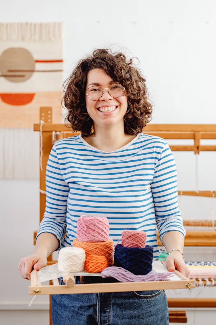 Female Weaver Holding A Loom And Yarn