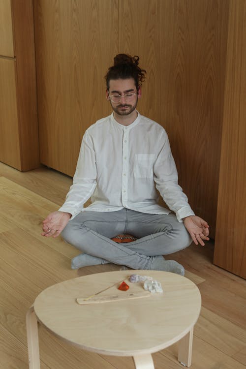 Man in White Long Sleeves and Gray Denim Pants Meditating