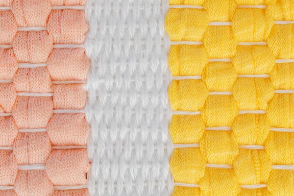 Pastel knitted fabric strips in pink, white and yellow — photo by Kaboompics on Pexels