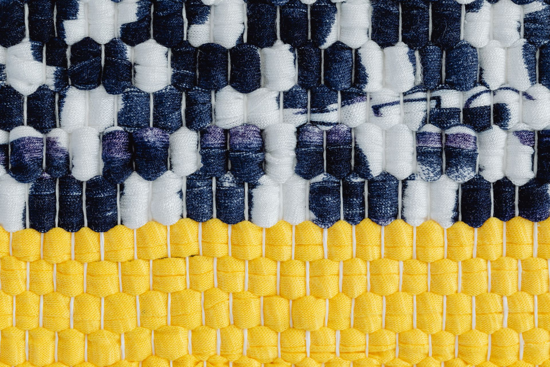 Detailed close-up of a handmade woven textile with distinctive colors and texture.