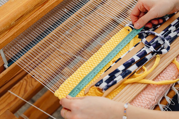 Woman Measuring The Weave On A Loom 