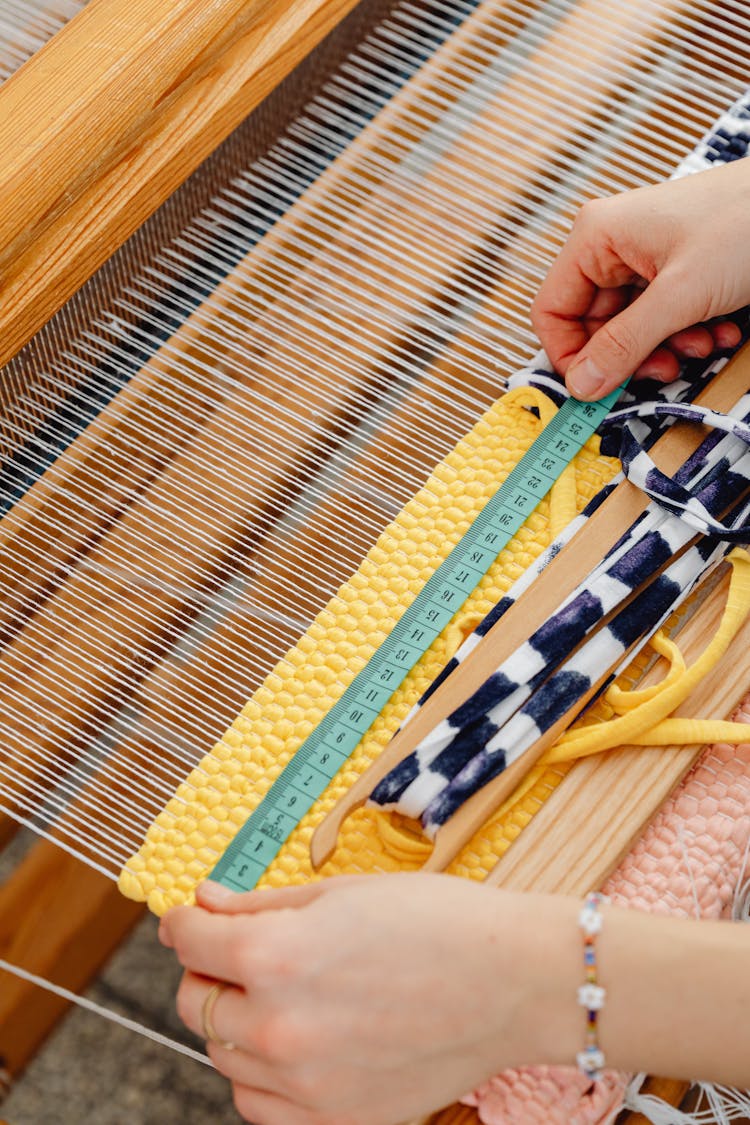 Close-up Of Person Weaving With Wool Threads