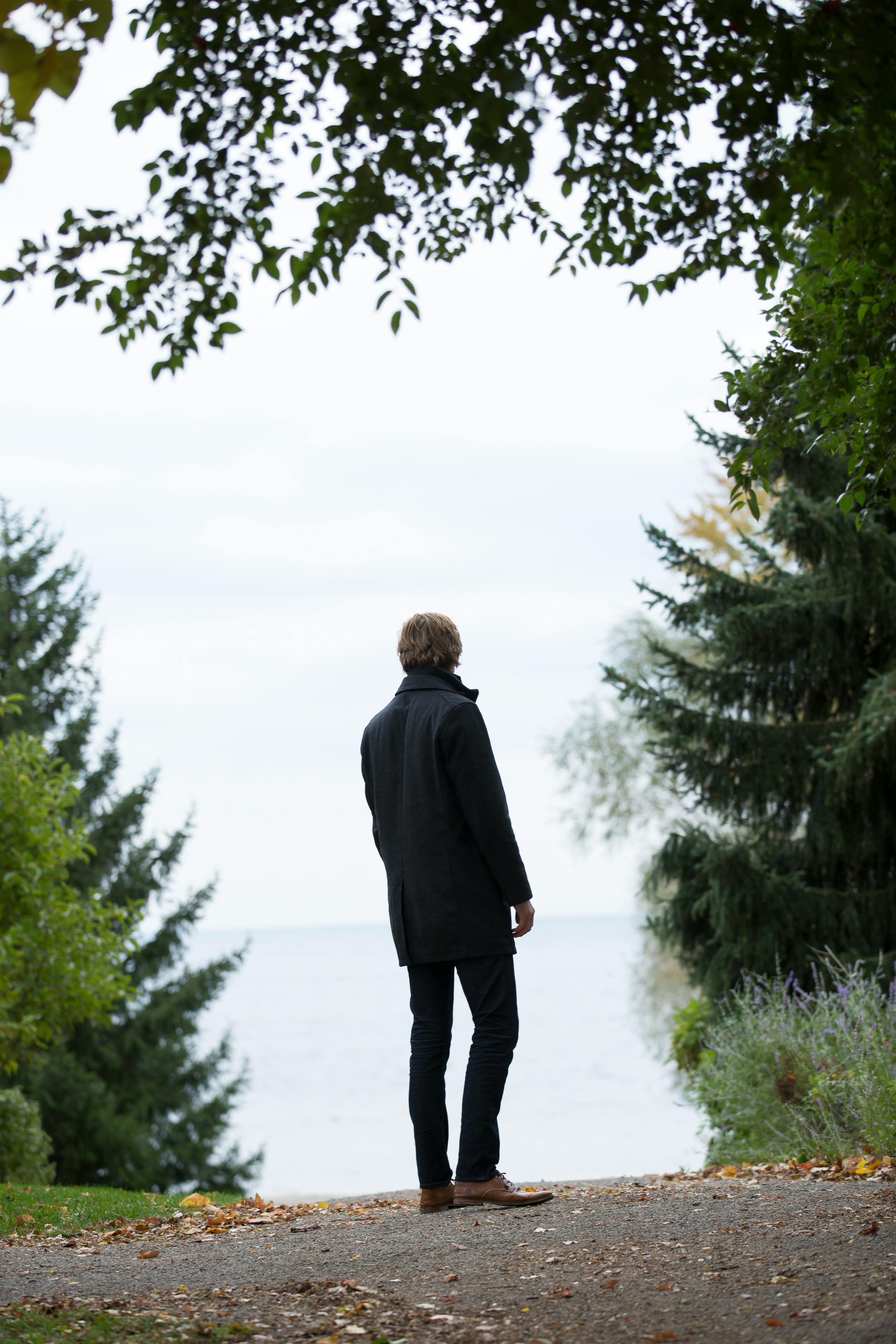 man standing in the middle of empty road