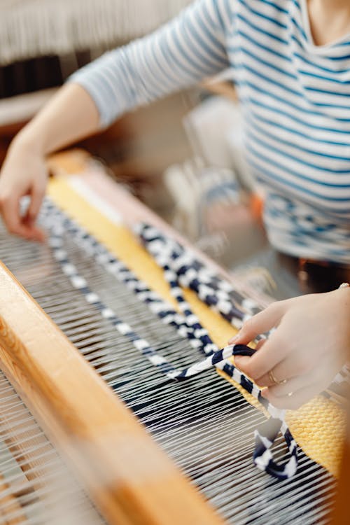 Close-up of the Hands of a Weaver Working with a Loom