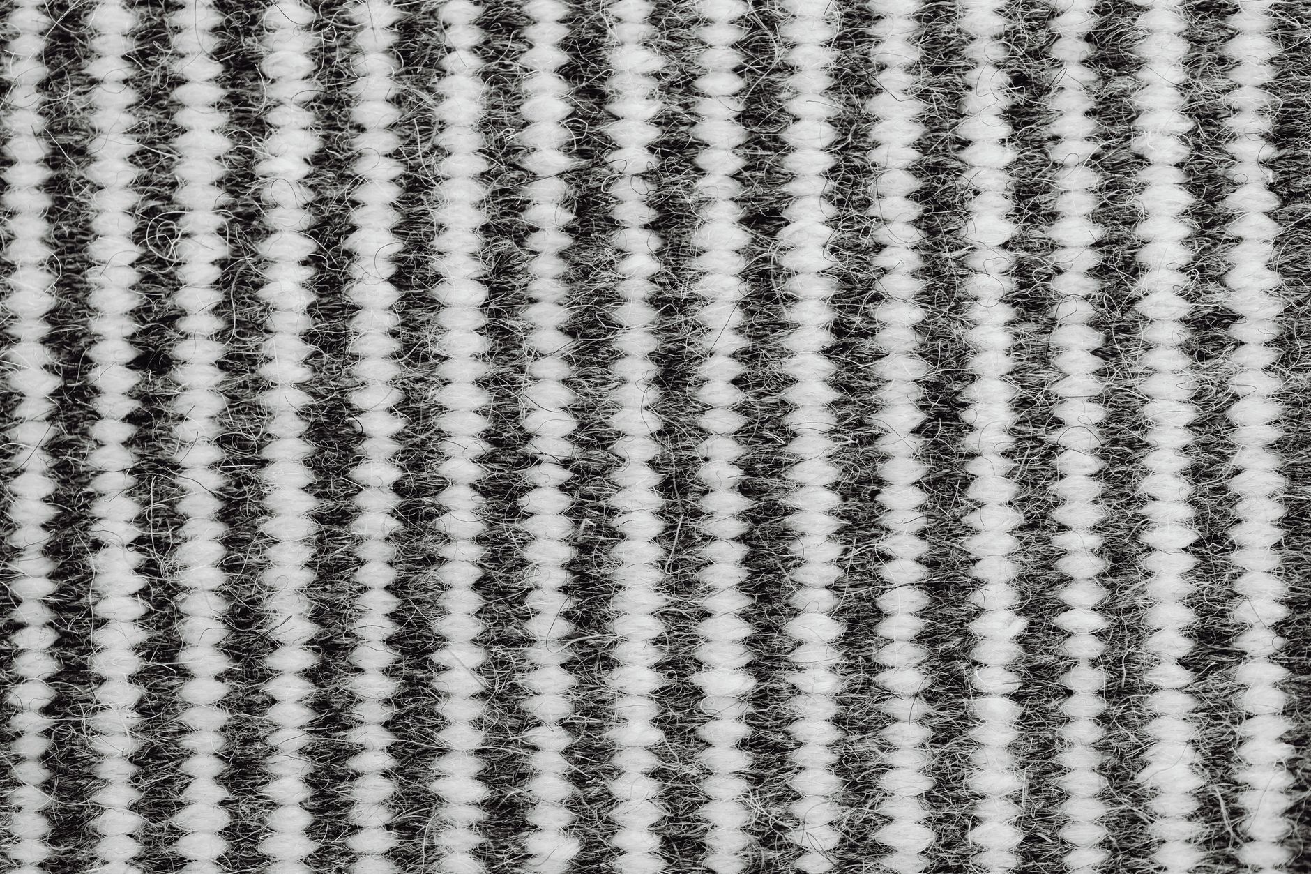 Detailed view of a woven black and white textile fabric pattern, highlighting texture and craft.