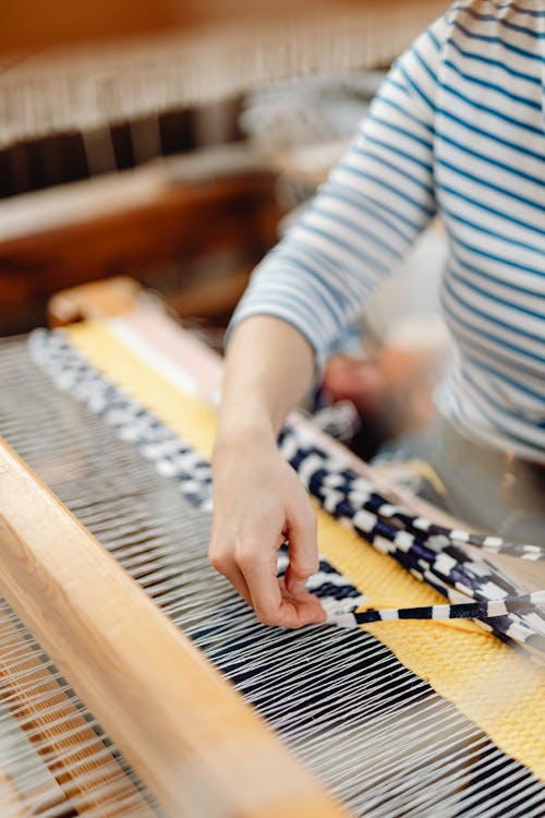 Free A Person Inserting Fabric in the Loom Stock Photo