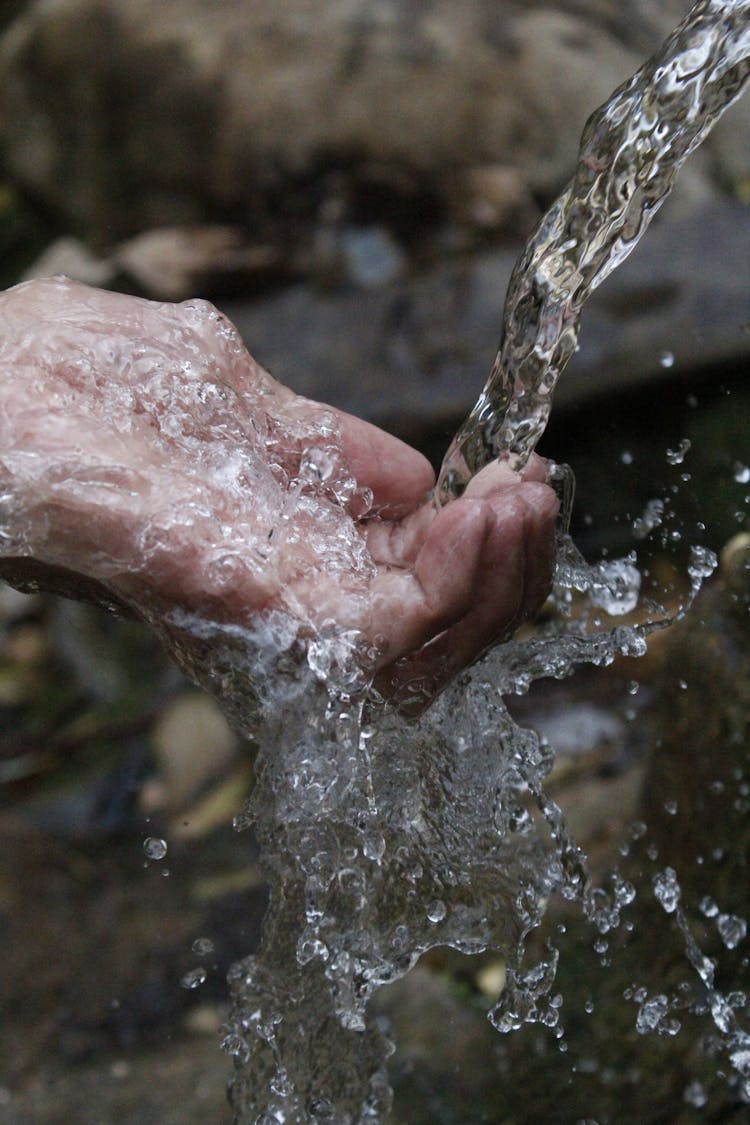 Person Cleaning Hands Under Water