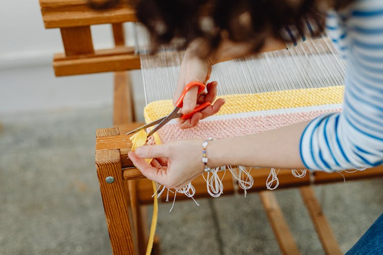 A Person Cutting Thread From A Fabric