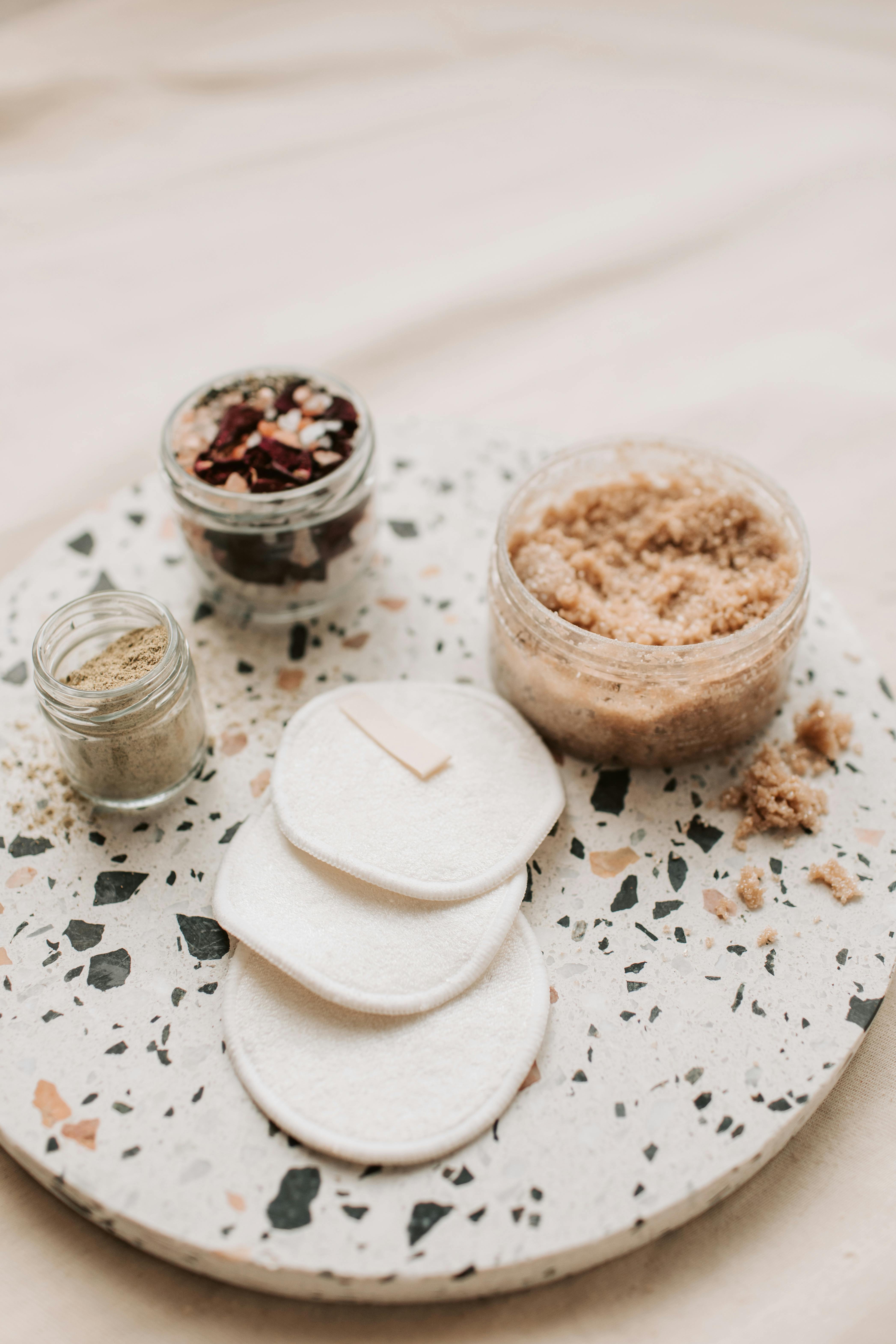 Free Zero Waste Cotton Pads Beside Body Scrub in Plastic Container Stock Photo