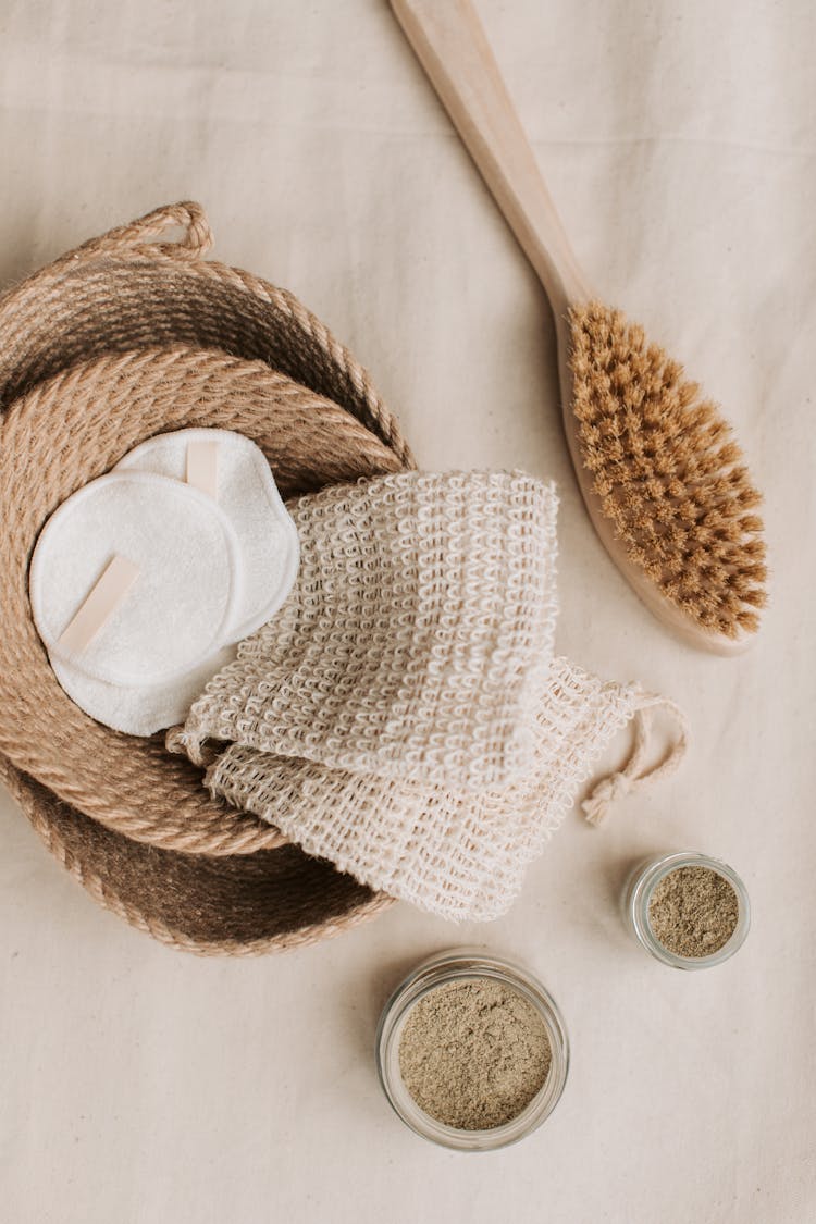 Hemp Washcloth And Cotton Pads In Braided Jute Basket Beside Wooden Brush