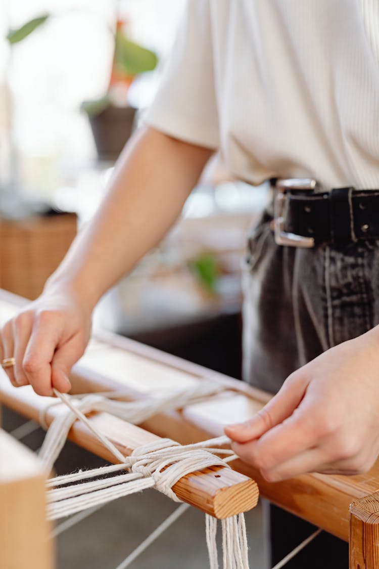 Unrecognizable Woman Weaver Tying Threads To Loom