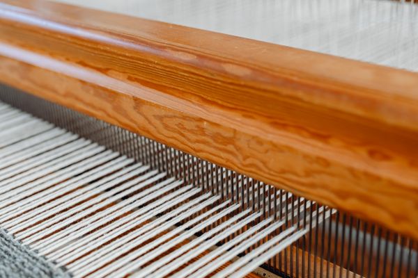 Warp yarn stretched across a wooden handloom — photo by Kaboompics on Pexels