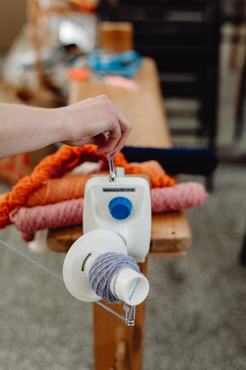 Yarn winding — a hand working with a yarn winder