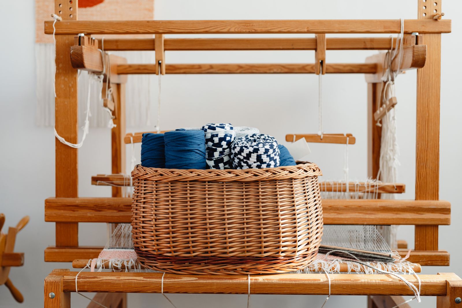 Basket of yarn resting on a wooden handloom, photo by Kaboompics on Pexels