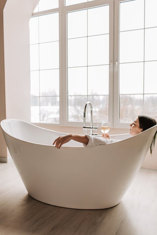 Woman in Bathtub in Front of Window