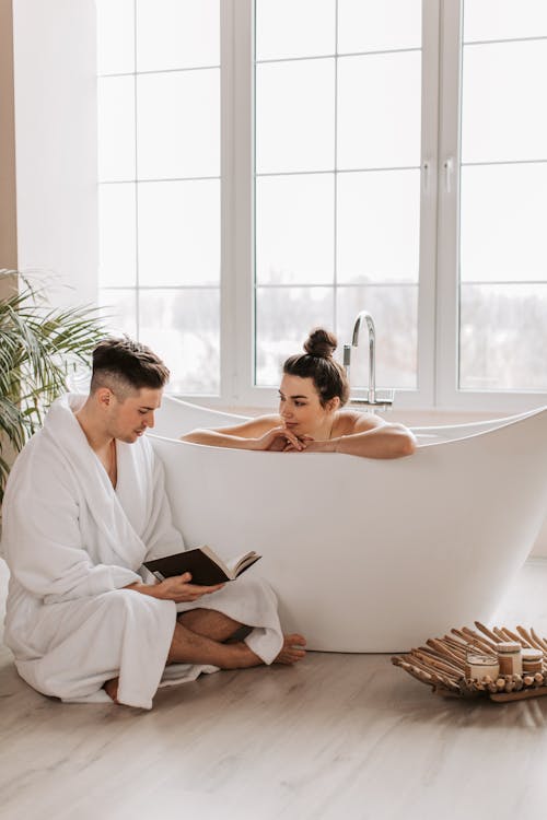 Man Reading a Book Beside a Woman