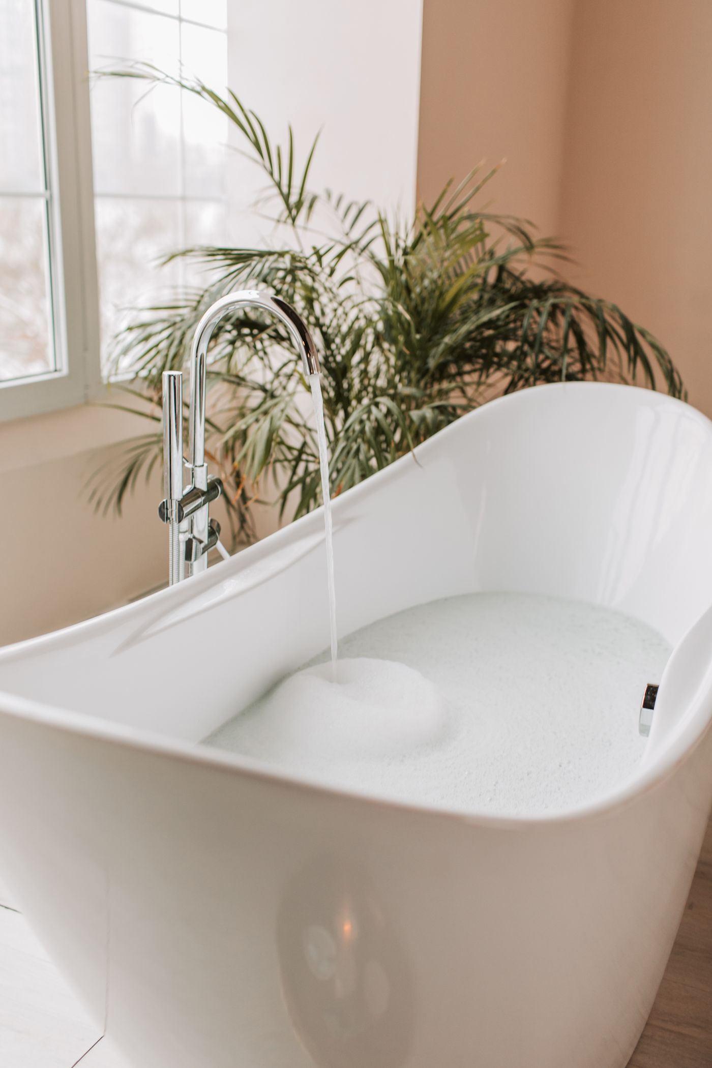 Ruhiges Wellness-Badezimmer mit Badewanne und grüner Pflanze