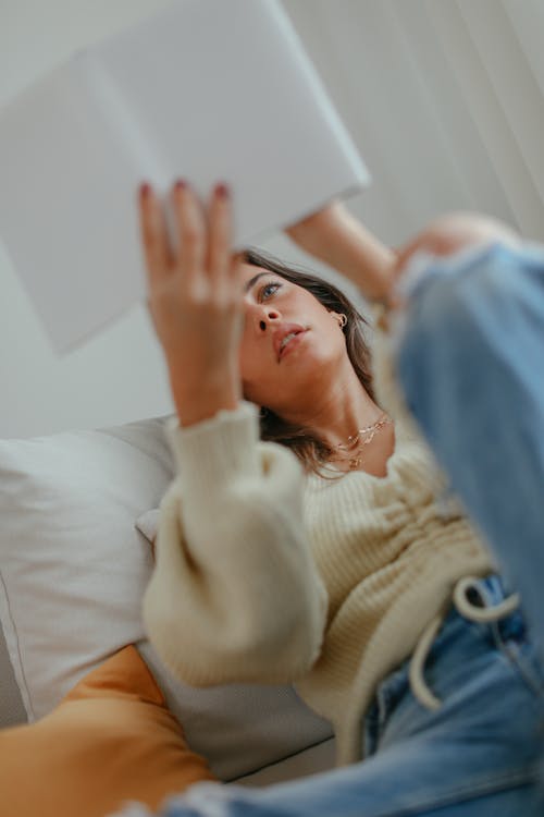 Beautiful Woman in Knitter Sweater Reading a Book