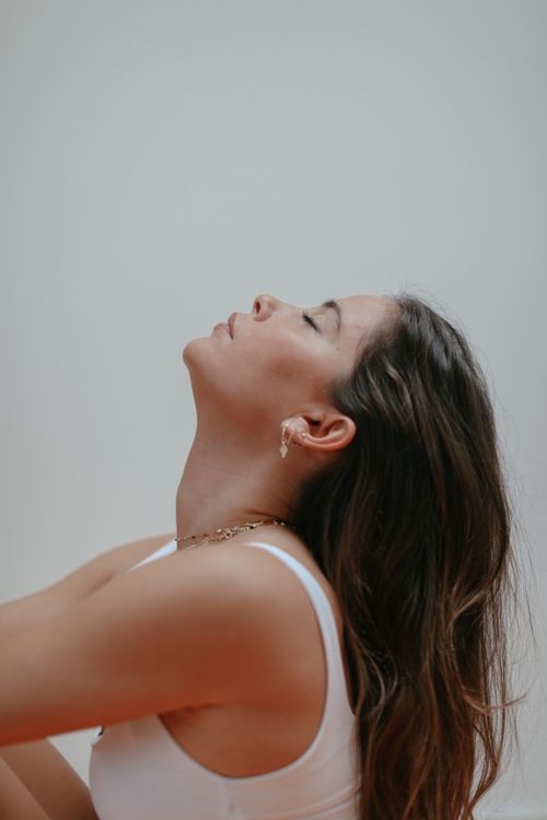 Free Side view of a woman with closed eyes relaxing indoors, exuding calmness. Stock Photo