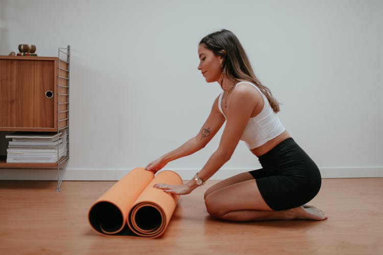 A Woman Rolling Out A Yoga Mat