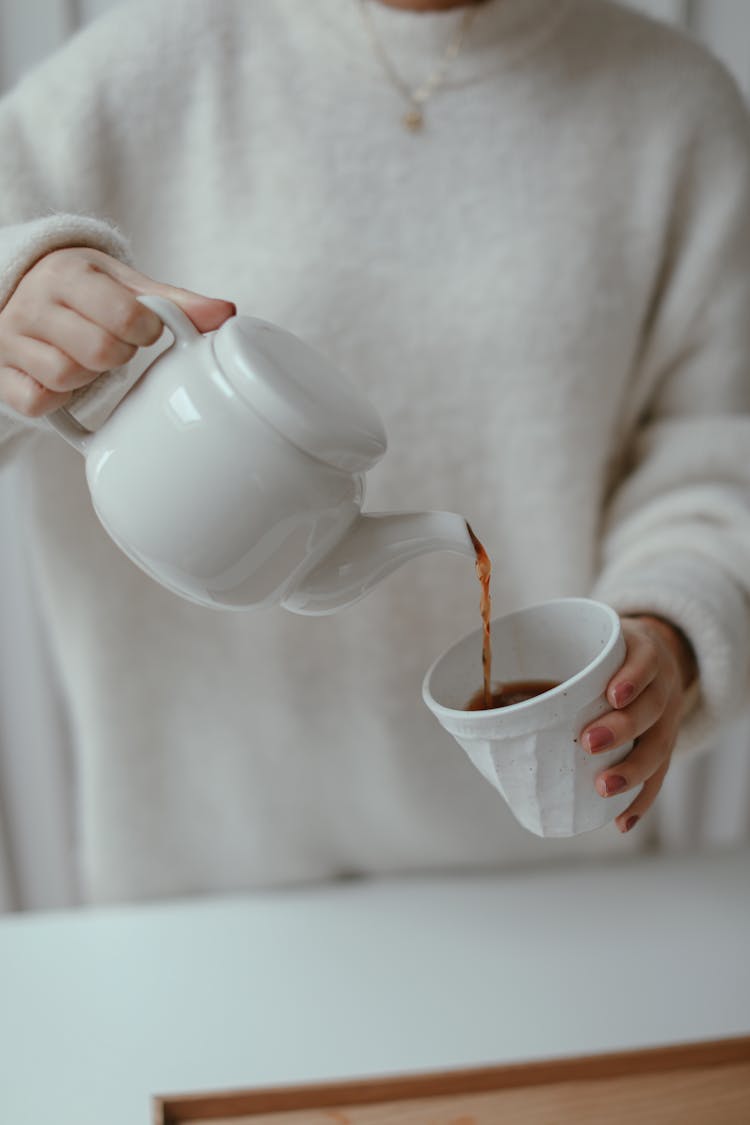 Person Holding A Teapot Pouring Tea