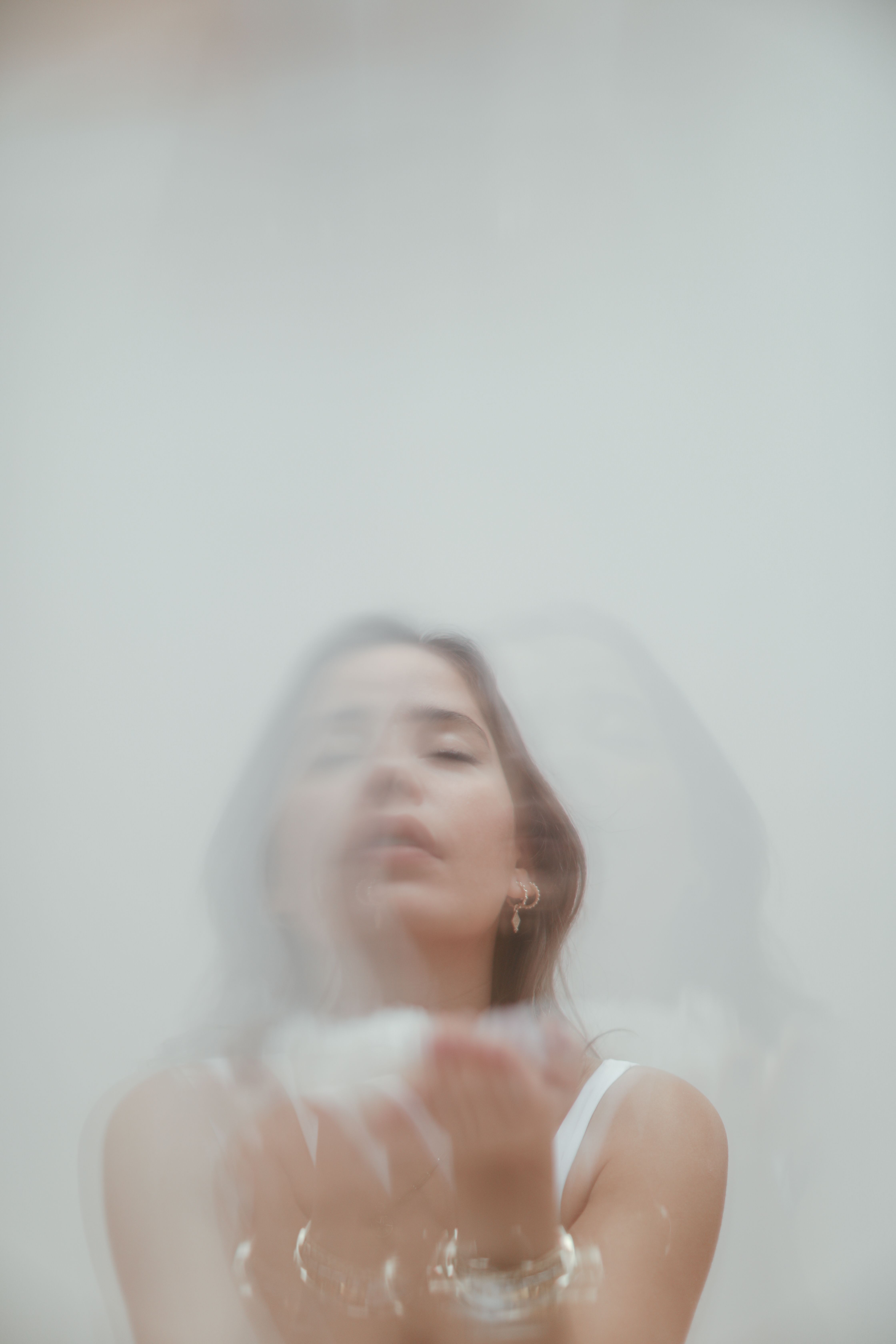 Dreamy double exposure portrait of a woman with ethereal blurred effect, creating a mystical feel.