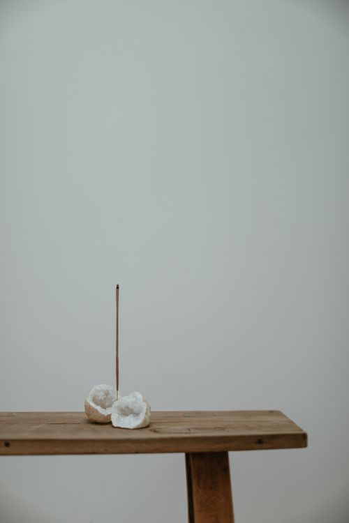 Free Serene white geode and incense stick on a wooden bench, minimalist setup. Stock Photo